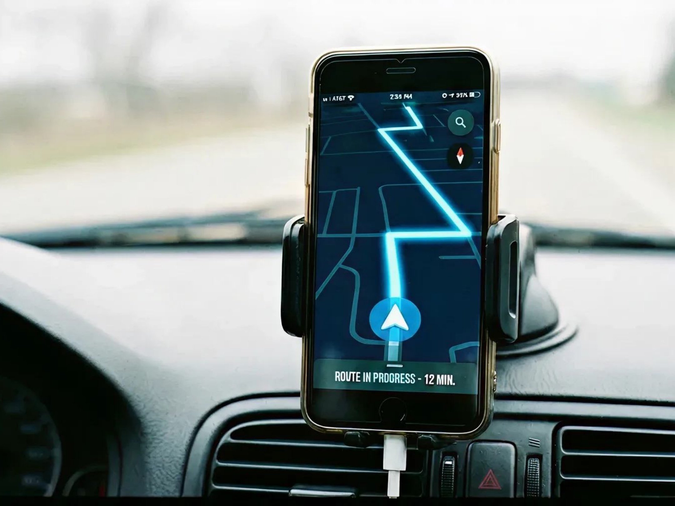 A phone on a car dashboard showing a GPS route